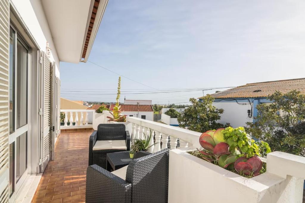 a balcony with chairs and tables on a building at Maison de vacances Casa Rocha in Armação de Pêra