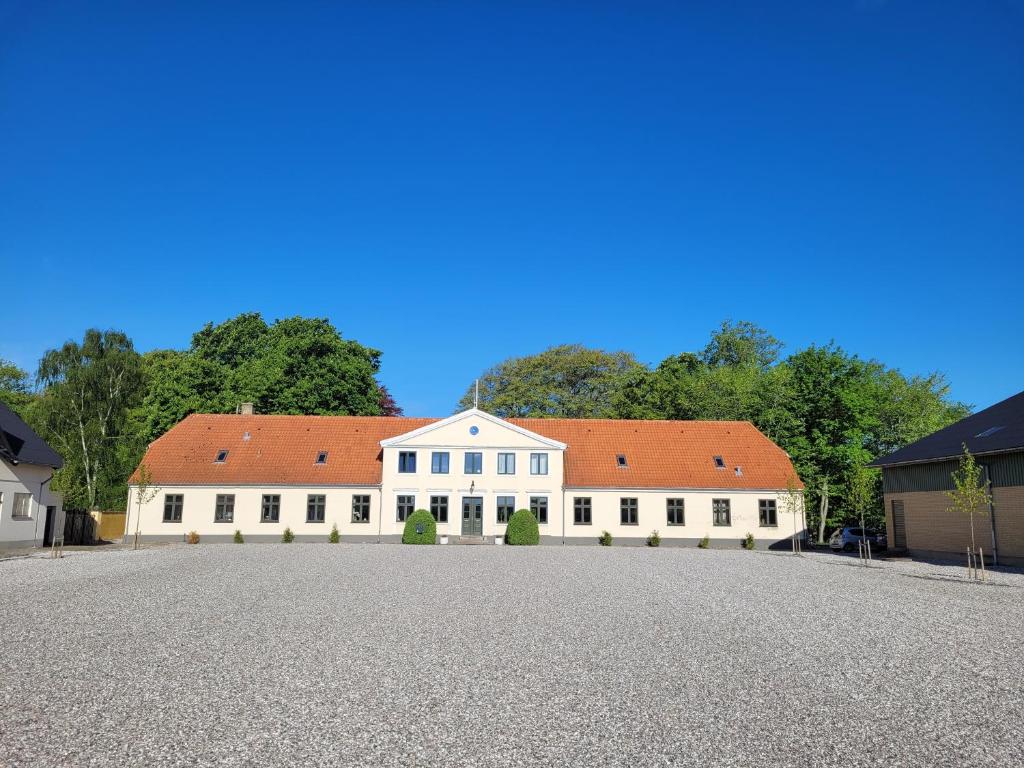 a large white building with a red roof at Privat lejlighed på landejendommen Frederiks-Eg in Herlufmagle