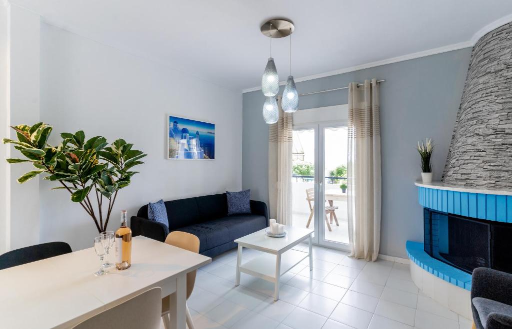 ein Wohnzimmer mit einer blauen Couch und einem Kamin in der Unterkunft Beachfront Bliss by halu! Spacious vacation house in Nea Skioni