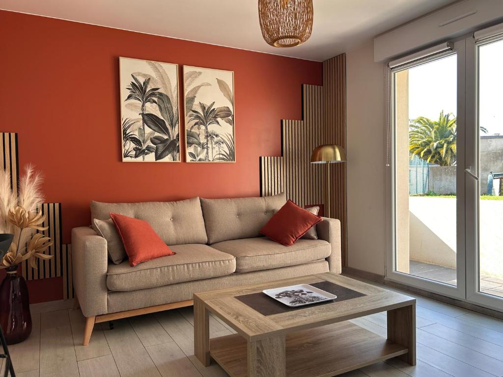 un salon avec un canapé et une table dans l'établissement L'Échappée belle - Séjour iodé près du parc, à Binic