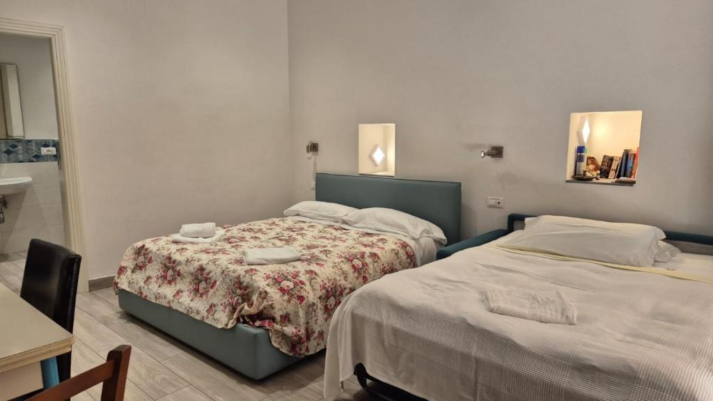 sypialnia z 2 łóżkami, stołem i lustrem w obiekcie Casa Isabella De Luxe Studio w mieście Monterosso al Mare
