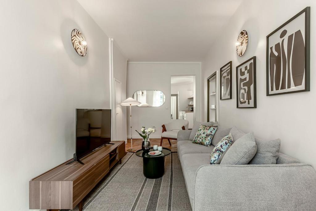 un salon avec un canapé et une télévision à écran plat dans l'établissement 32#Opera#GrandsBoulevards#Louvre#AC, à Paris