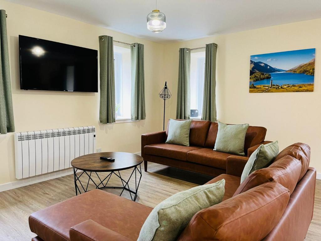 a living room with a couch and a table at Marina Apartments 1 in Corpach
