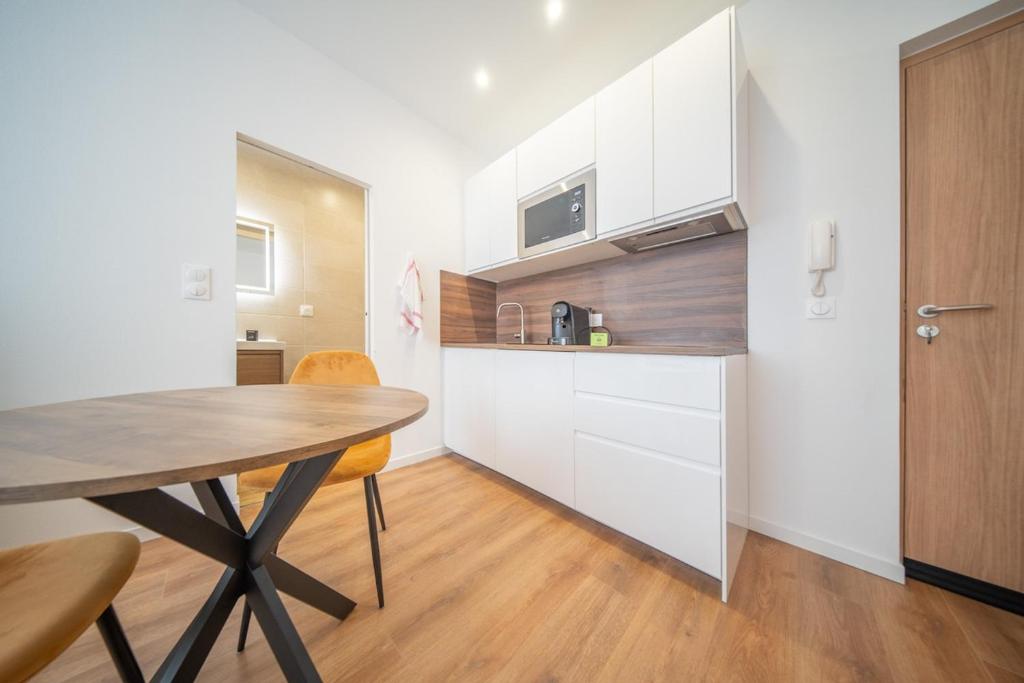 Hotel Super Appartement Near Basel 2 personnes 4, a kitchen with a wooden table and a dining room at Super Appartement Near Basel 2 personnes 4 in Saint-Louis
