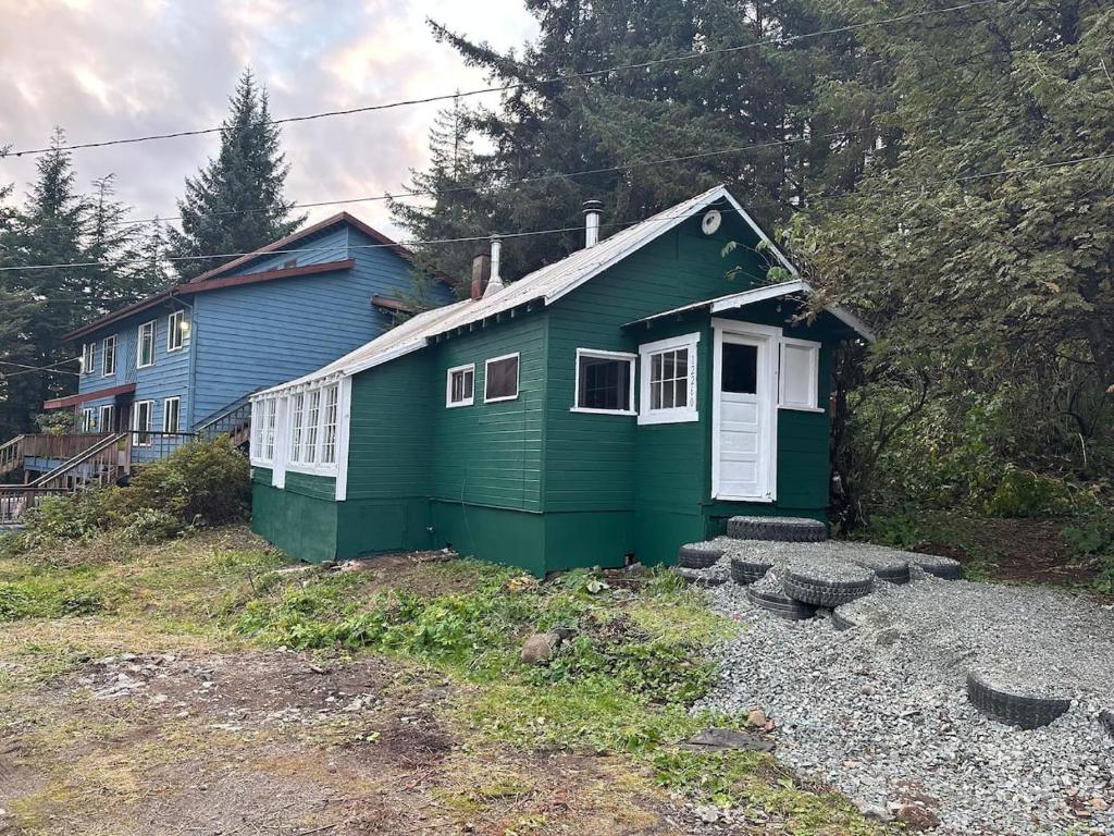 una casa verde in cima a una collina di The Auke Ridge Retreat Cabin - a Short Walk to the Harbor a Mendenhaven