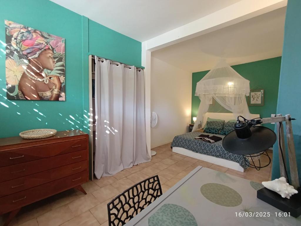Habitación con dormitorio con cama y vestidor. en La Perle Rose {3 ch. - 6 à 8 pers.}, en Sainte-Rose