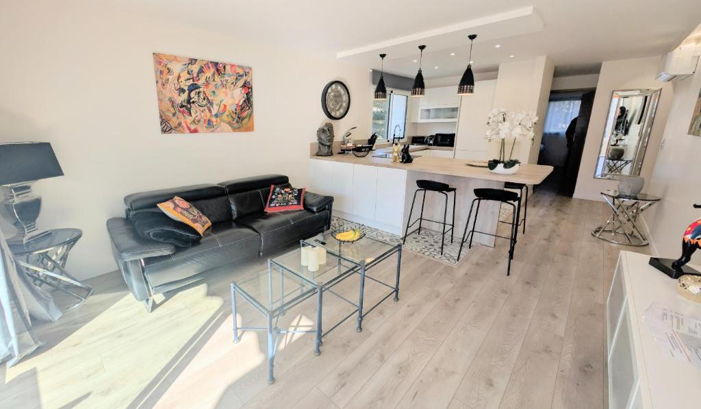 un salon avec un canapé noir et une cuisine dans l'établissement 