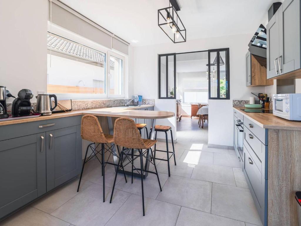 a kitchen with a table and some chairs in it at Charmante Maison à Quentovic, 3 Chambres - FR-1-821-21 in Le Touquet-Paris-Plage