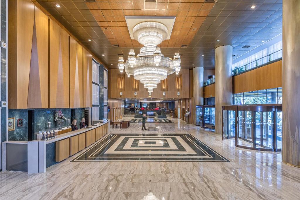una hall di un edificio con lampadario pendente di Divani Caravel ad Atene