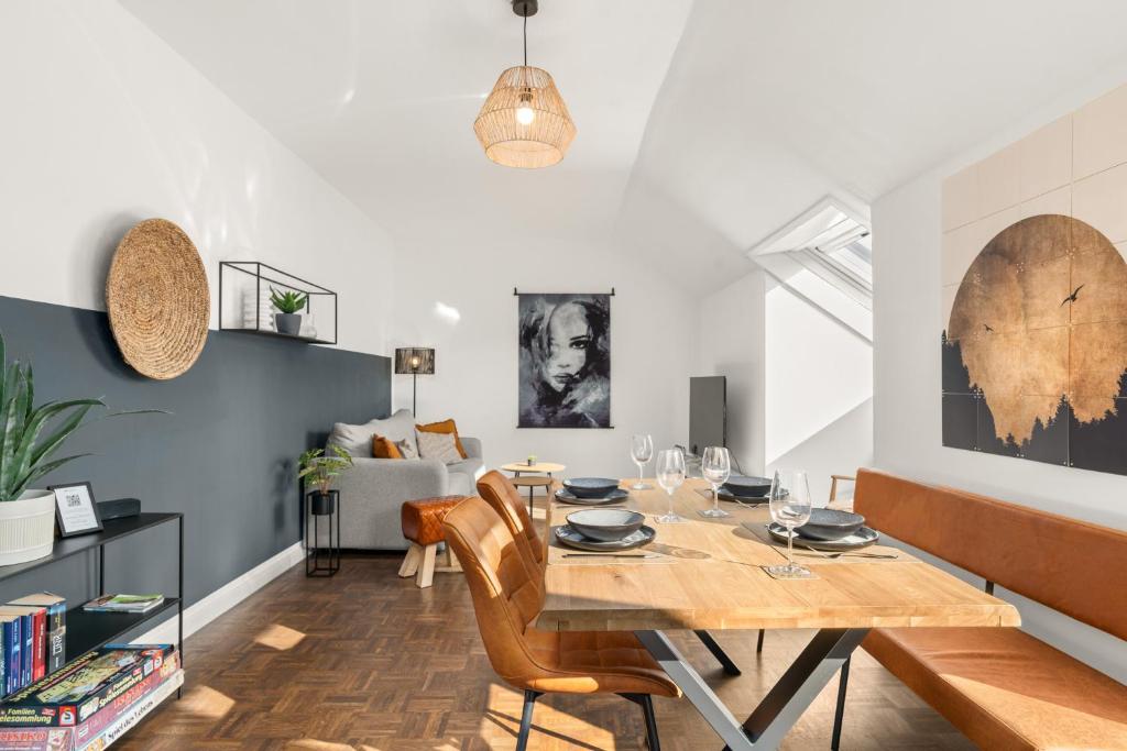 a dining room and living room with a table and chairs at SOMERSET - 2 Whg in einem Haus, max 10 Pers, BBQ, Balkon, PS5 in Bad Berleburg