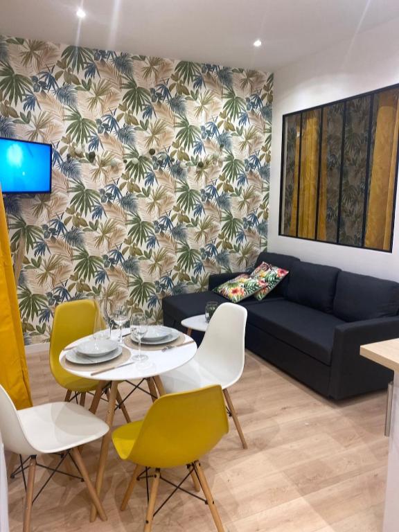 un salon avec un canapé, une table et des chaises dans l'établissement La Maison du Soleil, à Luxeuil-les-Bains