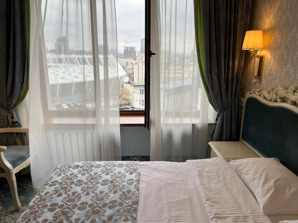Postel nebo postele na pokoji v ubytování Royal Olympic Hotel