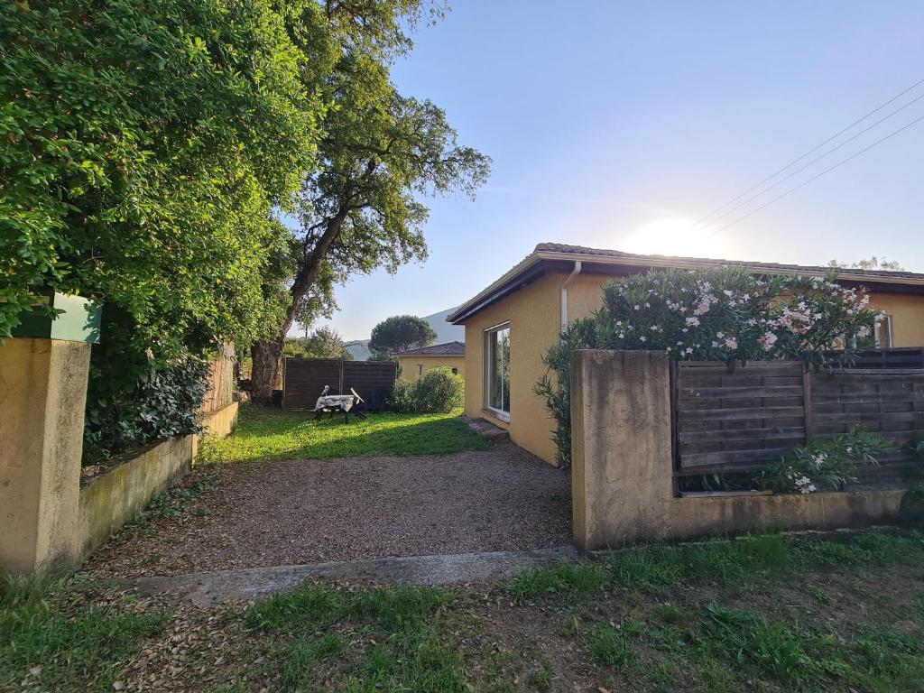 une arrière-cour d'une maison avec une clôture dans l'établissement Casa Rossu - Gite indépendant Accès Piscine, à Appietto