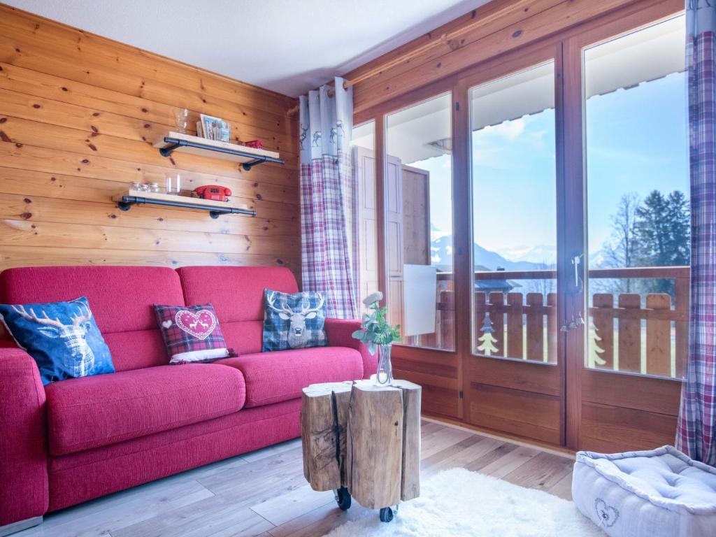 a living room with a red couch and a wooden wall at Apartment Villars Vacances 20 by Interhome in Villars-sur-Ollon