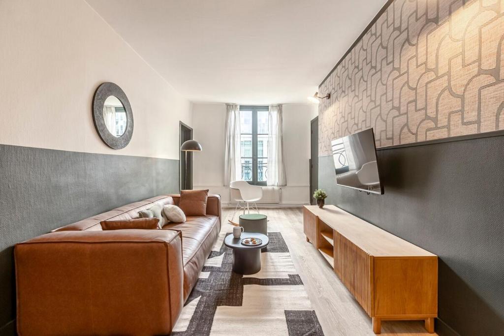 un salon avec un canapé et une télévision dans l'établissement 42#Opera #Louvre #Paris02 #2bedrooms #AC, à Paris