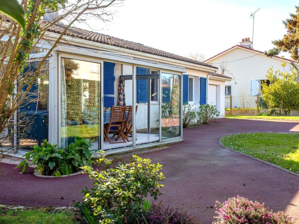 ein Haus mit Glasschiebetüren und einer Terrasse in der Unterkunft Holiday Home La Bruyère by Interhome in La Bernerie-en-Retz