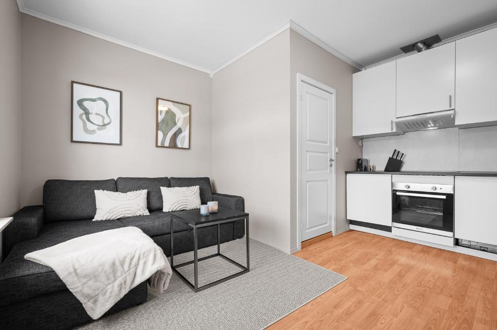 a living room with a couch and a kitchen at Sentral 1BR i Porsgrunn - P Apartments in Porsgrunn