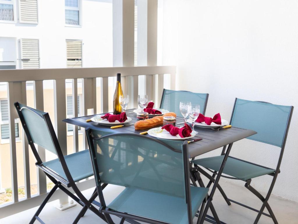 - une table avec des chaises et de la nourriture sur le balcon dans l'établissement Apartment Atlantica-3 by Interhome, à Pornic