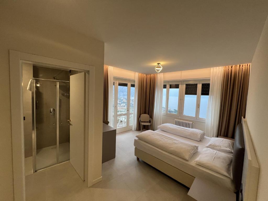 a bedroom with a bed and a walk in shower at Hotel Villa Margherita in Limone sul Garda