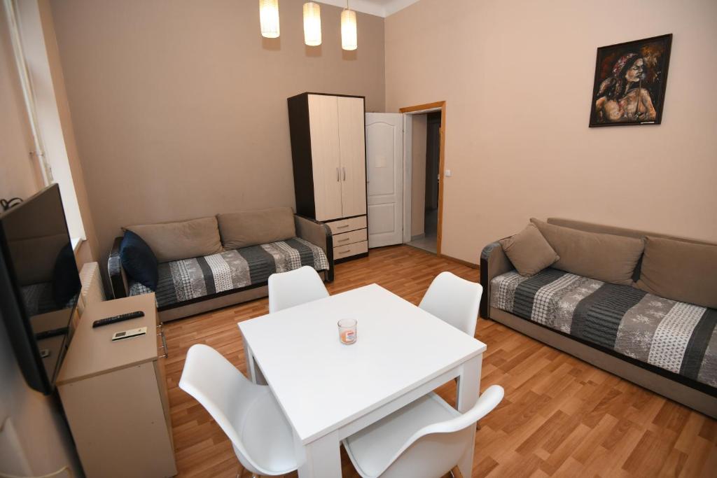 un soggiorno con un tavolo bianco e un divano di Apartments Downtown Novi Sad a Novi Sad
