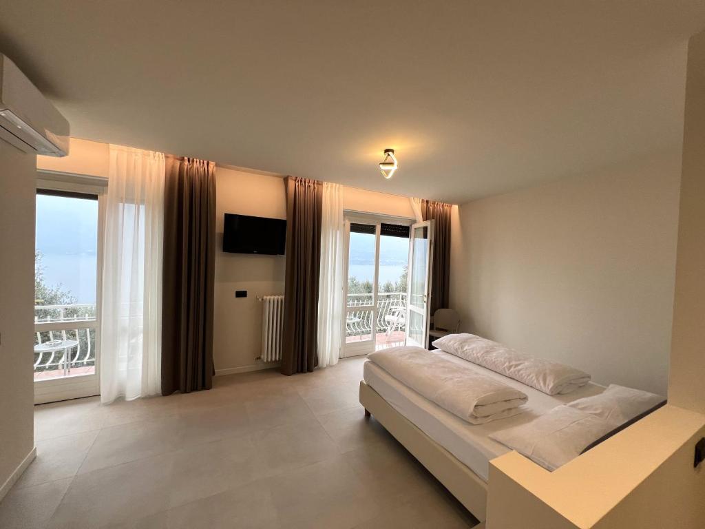 a bedroom with a bed and a large window at Hotel Villa Margherita in Limone sul Garda