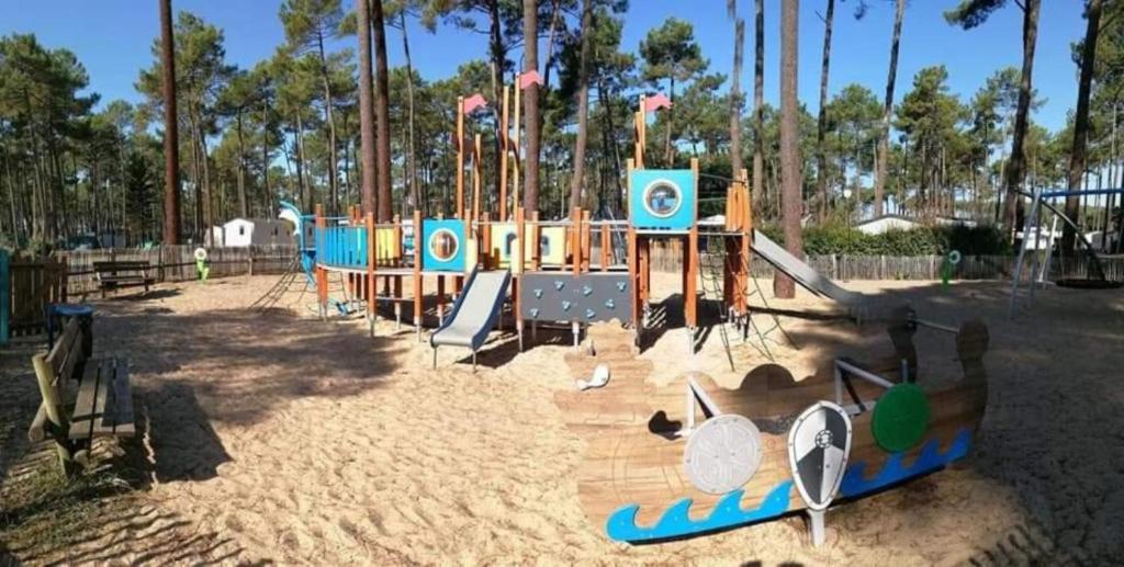 - une aire de jeux dans un parc avec un toboggan et un toboggan dans l'établissement MH 395 3 chambres et 1 salle de bain dans camping 4 étoiles, à Saint-Julien-en-Born