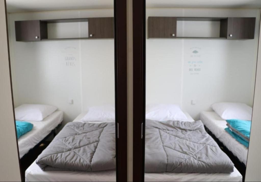 - 2 lits superposés dans une chambre avec un miroir dans l'établissement MH 395 3 chambres et 1 salle de bain dans camping 4 étoiles, à Saint-Julien-en-Born 17 autres photos