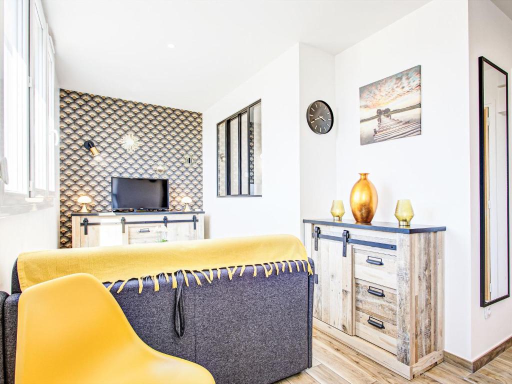 un salon avec un banc jaune et une télévision dans l'établissement Apartment Ajoupa-6 by Interhome, à Canet