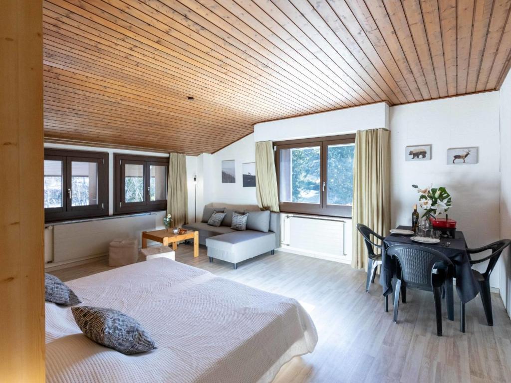een slaapkamer met een bed, een tafel en een bureau bij Apartment Gamat 49 by Interhome in Villars-sur-Ollon