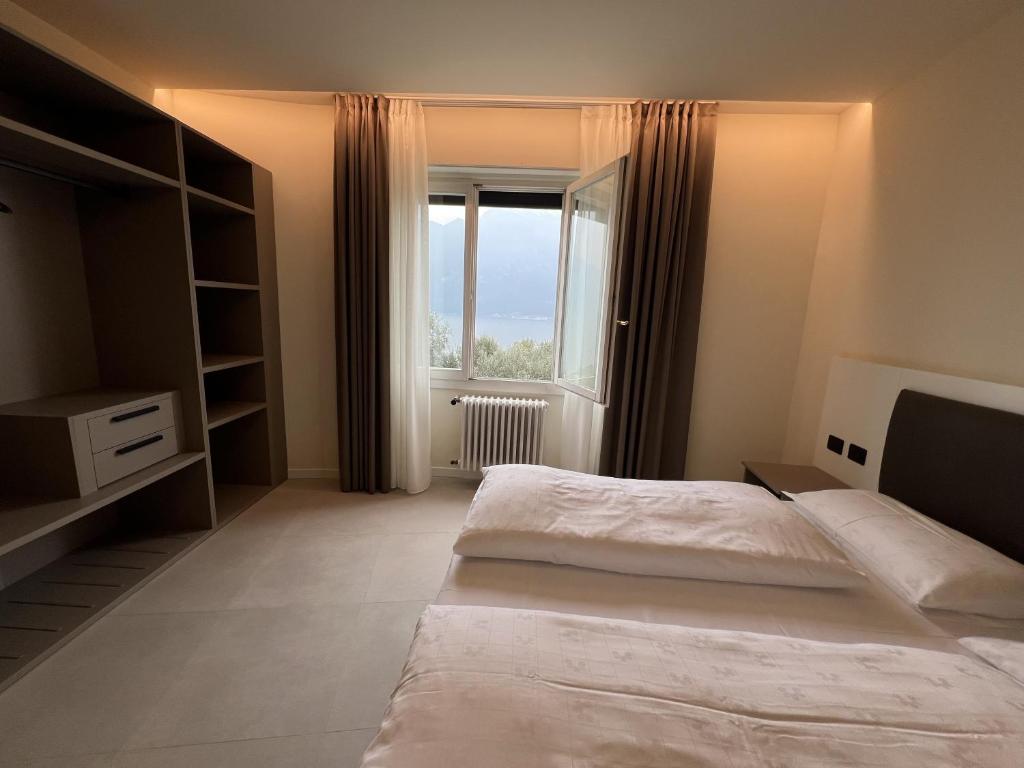 a bedroom with a large bed and a window at Hotel Villa Margherita in Limone sul Garda