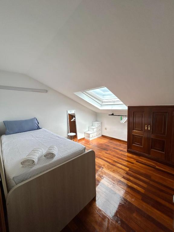 1 dormitorio con 1 cama grande y tragaluz en Apartamento Aqua Marina, en O Grove