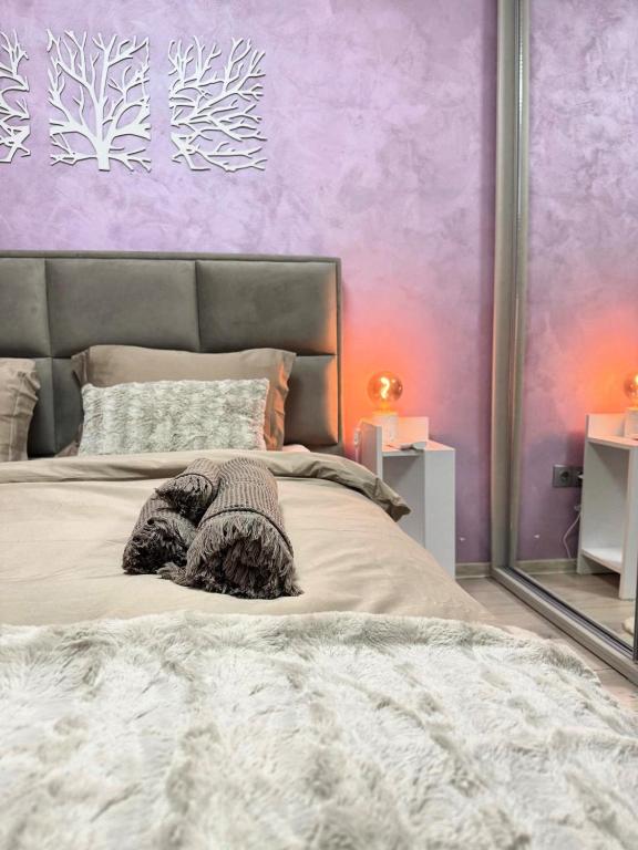 a bedroom with a large bed with a purple wall at Elegant Old Town Escape in Bucharest