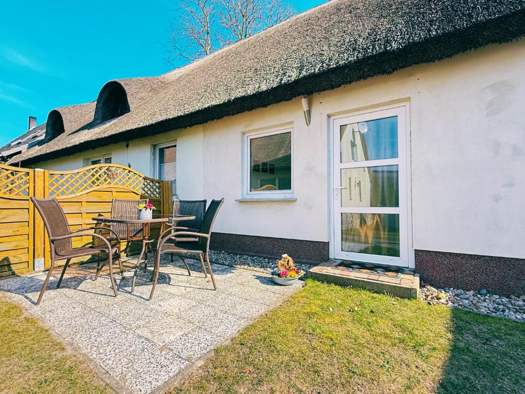 a patio with chairs and a table in front of a house at Ferienwohnung 3 & 4 Wald & See in Zirchow