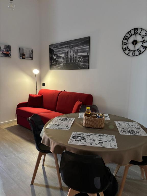 a living room with a table and a red couch at B&B Certosa Fiera in Milan