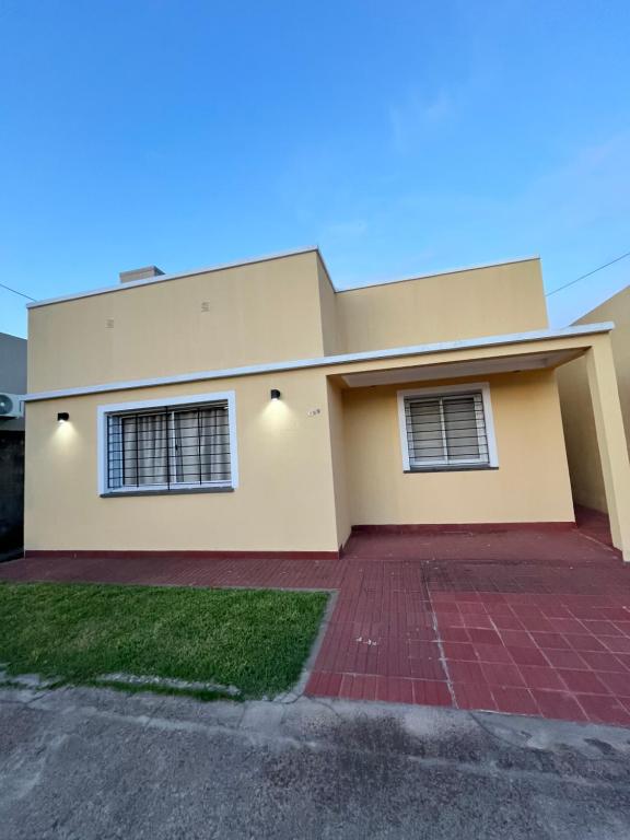 a house with a blue sky in the background at Casa en alquiler temporario in Ramallo