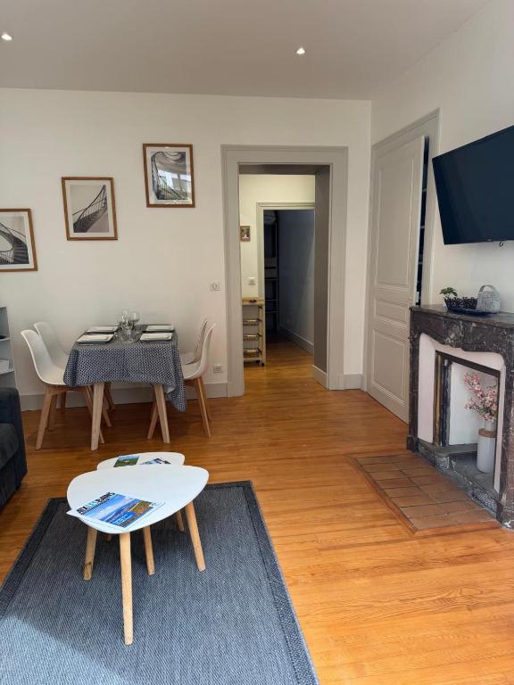 un salon avec une table et une cheminée dans l'établissement Le Vivaldi 33 m - parking, à Aix-les-Bains