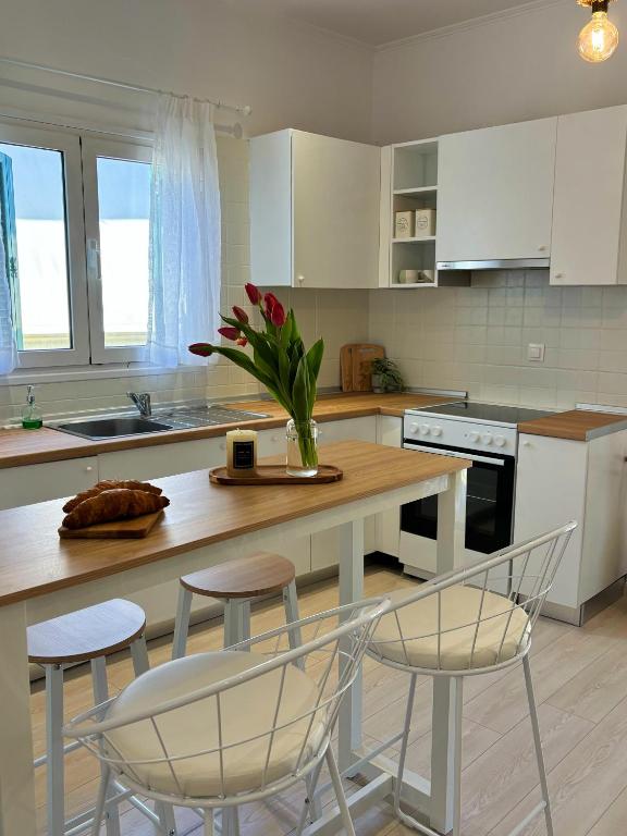 a kitchen with a table with chairs and a vase with flowers at Casa Daphne in (( Agía Eleoúsa ))