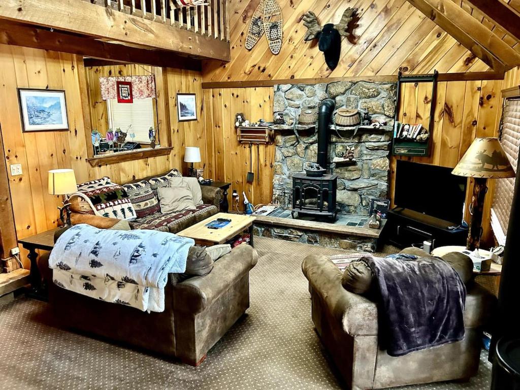 a living room with a stone fireplace in a cabin at Quiet Maine Cabin Getaway in Lebanon