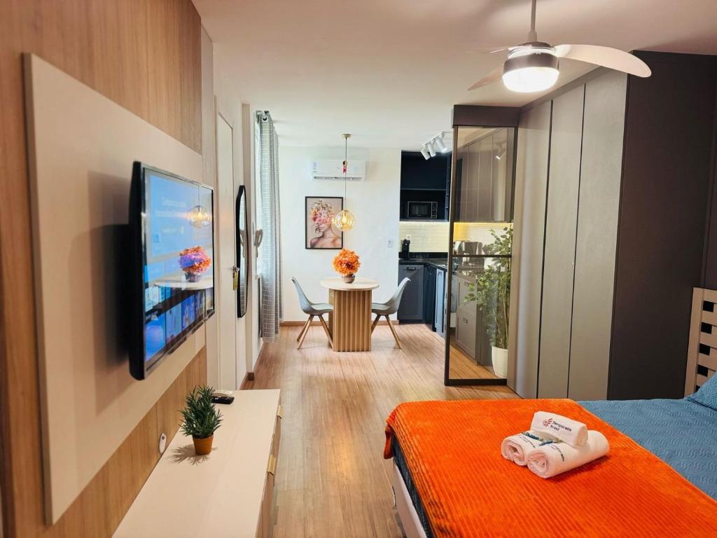 a room with a bed and a television and a table at Modern Studio in Catete – Close to the Metro in Rio de Janeiro
