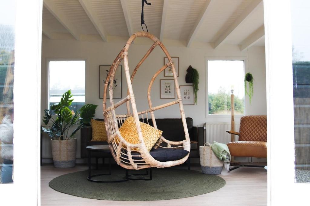 eine Schaukel mit hängendem Korb im Wohnzimmer in der Unterkunft Cozy cottage in the heart of the Veluwe in Putten