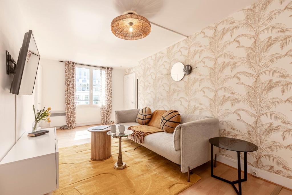 un salon avec un canapé et une télévision dans l'établissement 52#Opera#Grands Boulevards#Paris02, à Paris