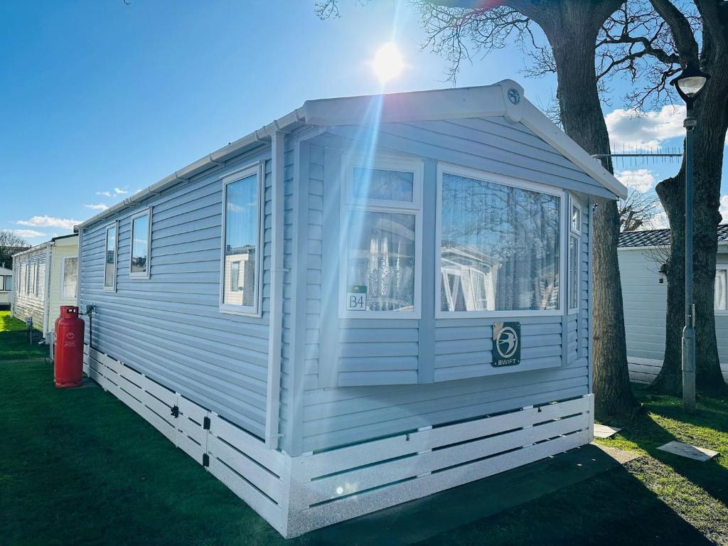 a white tiny house parked next to a tree at Island Escape Sandown in Sandown