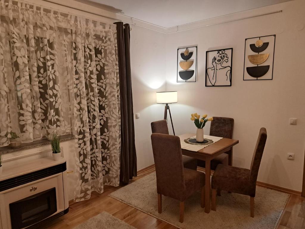 a dining room with a table and chairs and a fireplace at Apartaman Sweet Home in Bačka Palanka