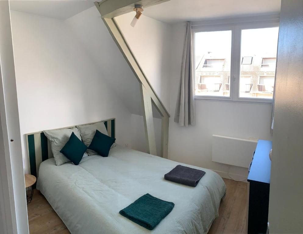 une chambre avec un lit avec deux oreillers dessus dans l'établissement Appartement La case a vent, à Fort-Mahon-Plage