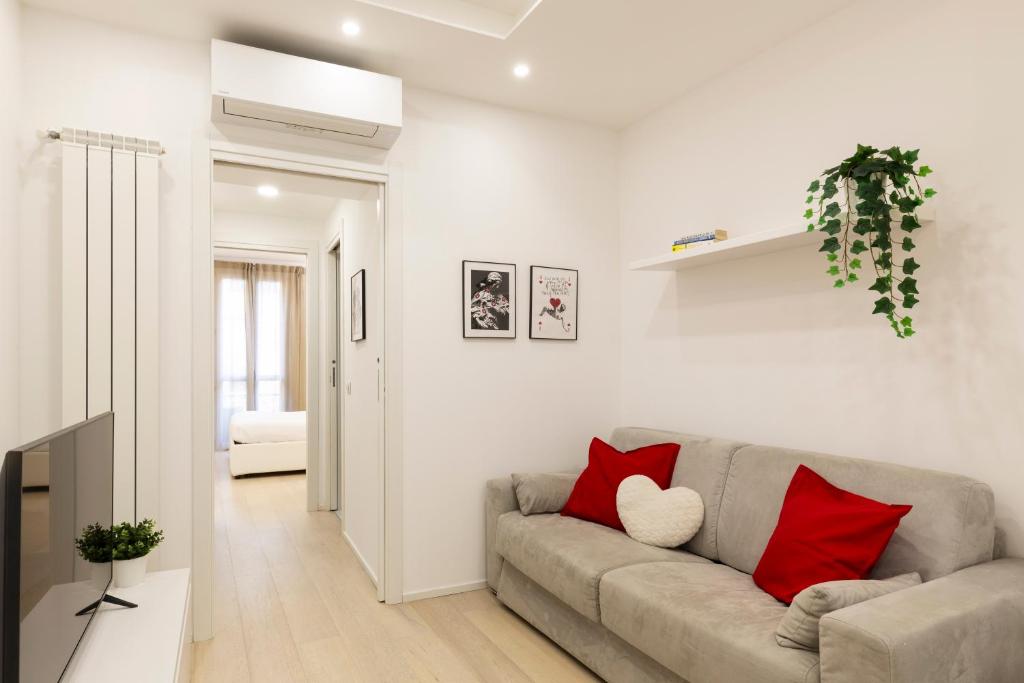 een woonkamer met een grijze bank en rode kussens bij Campus Bligny - Bocconi District in Milaan