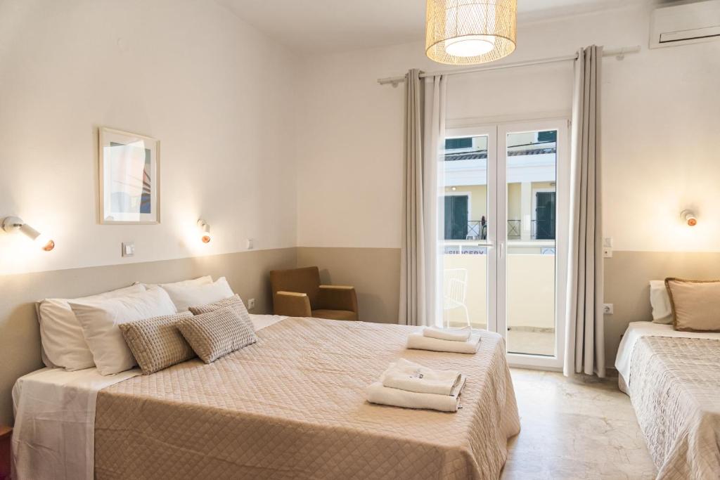 a bedroom with two beds with towels on them at BOHOTEL Eleonas Anex Apartments in Kavos