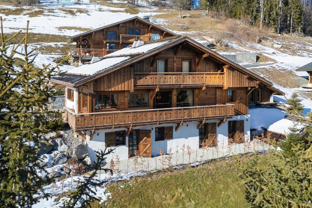 a large wooden house with snow on the roof at Chalet de Luxe Saint Gervais avec Vue ,Spa, Jacuzzi, Salle de sport in Saint-Gervais-les-Bains