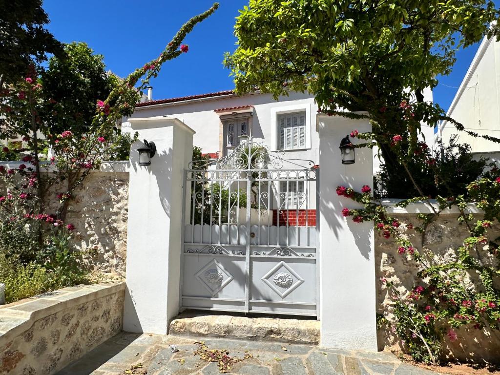 a white gate in front of a house at MantasHouse in Spetses