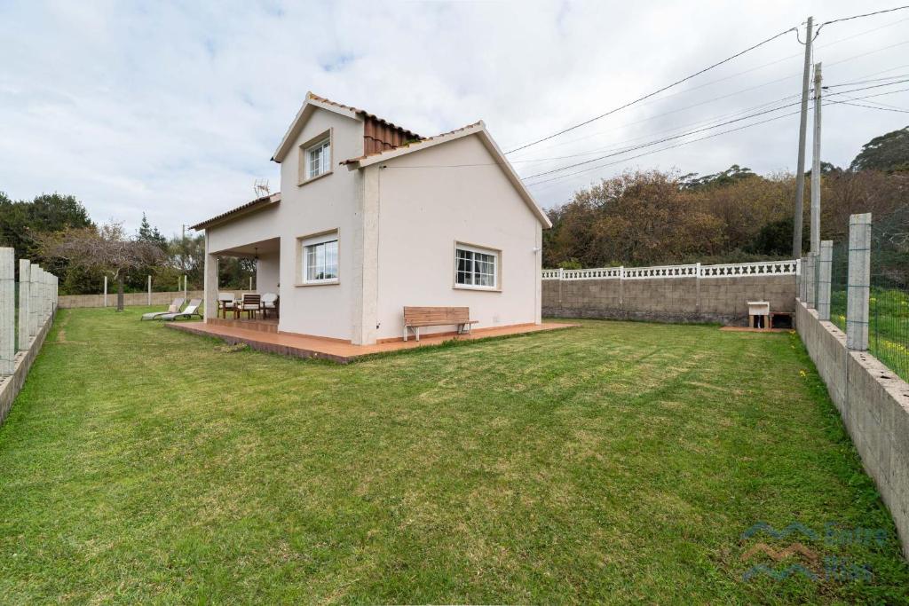 a small white house with a grass yard at Casa de Pili - by entreRías in Cangas de Morrazo