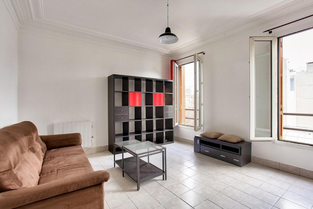 un salon avec un canapé et une table dans l'établissement Cocon calme et lumineux - Clichy, à Clichy